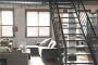 Coin salon lumineux avec canapé, fauteuil et banc près d'une grande fenêtre