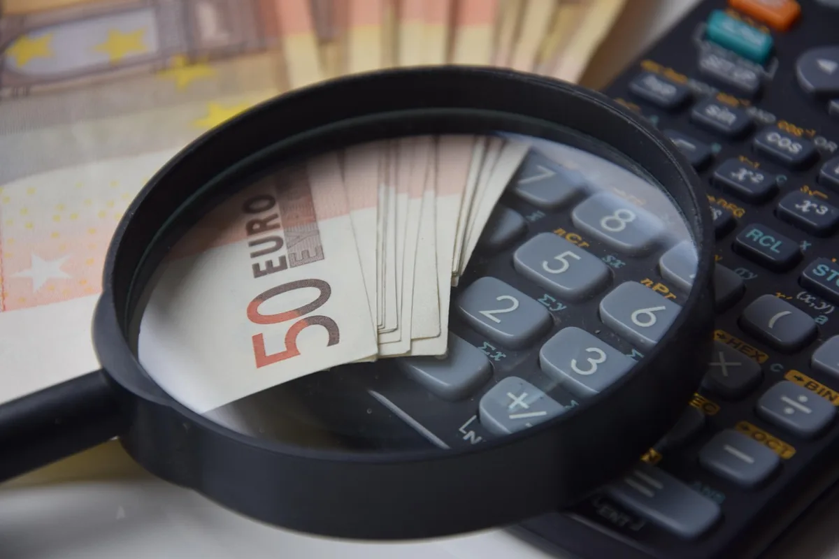 Documents notariaux et calculatrice sur une table pour estimer les coûts