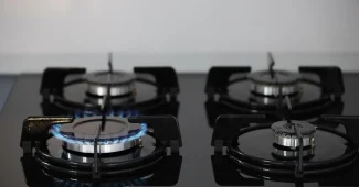 Mains anonymes ajustant un thermostat près d’une chaudière avec une facture de gaz sur la table