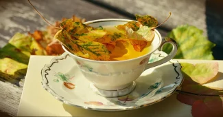 Mains saupoudrant de la cannelle sur une pelouse ensoleillée avec des feuilles mortes floues